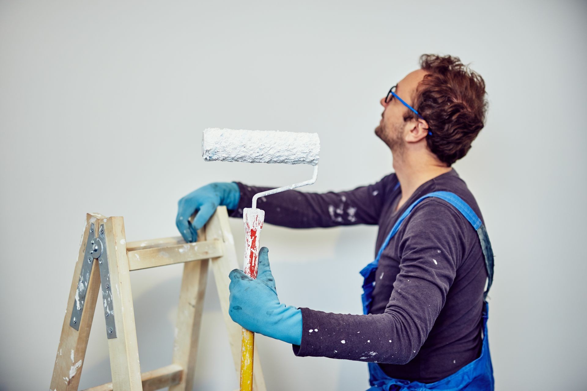 Worker painting walls inside the house - renovation fixes.